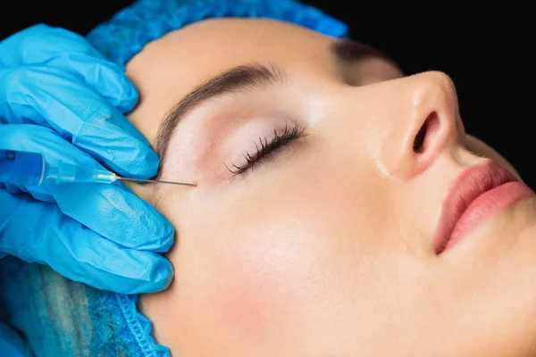 Woman receiving botox injection on forehead — Stock Photo, Image