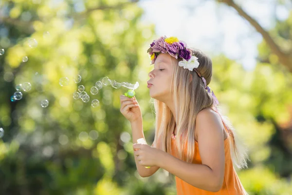 Jong meisje blaast bellen via bubble wand — Stockfoto