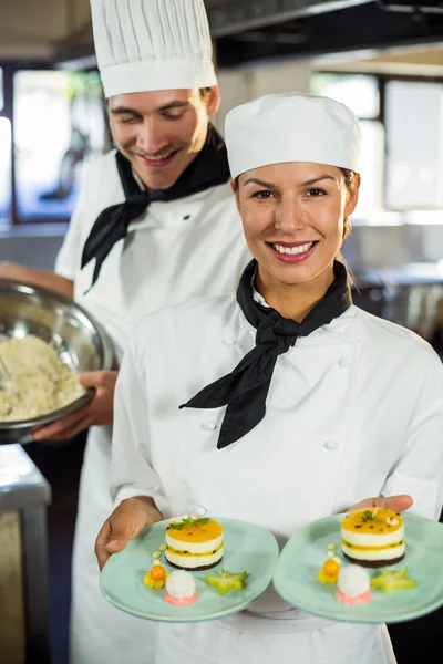 Vrouwelijke chef-kok presenteert dessert platen — Stockfoto