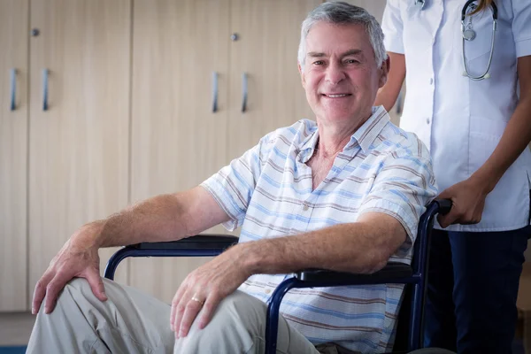 Vrouwelijke arts die senior man rolstoel — Stockfoto