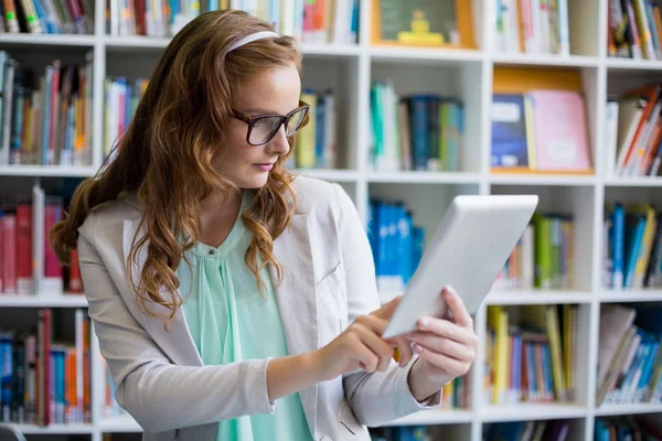 Nauczyciel za pomocą tabletu w bibliotece — Zdjęcie stockowe