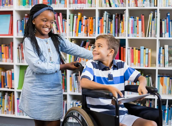 Studentessa con ragazzo disabile sulla sedia a rotelle — Foto Stock