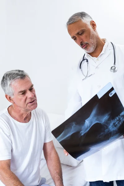 Врач-мужчина обсуждает рентген со старшим мужчиной — стоковое фото