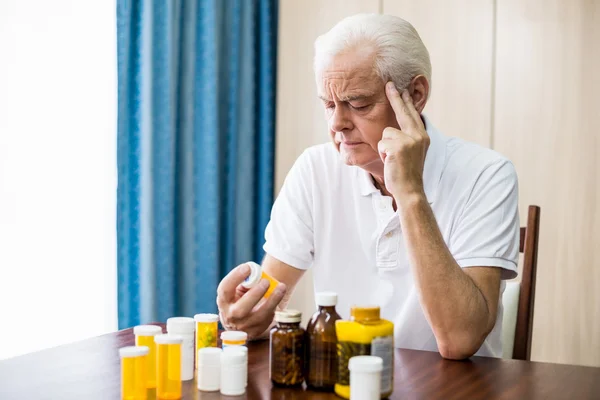 Senior sitter framför medicin — Stockfoto