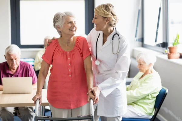Zdravotní sestra pomáhá senior s pohybovými pomoci — Stock fotografie