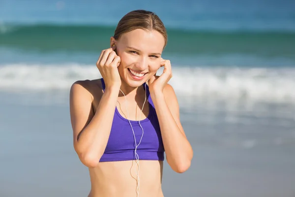 Mulher ouvindo música durante o exercício — Fotografia de Stock