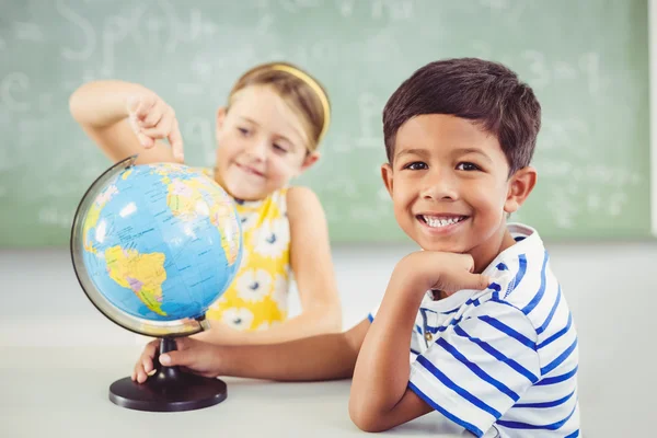 School kids with globe in classroom — Stock Photo, Image