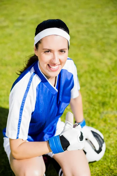 Happy soccer player sitting with a ball — Stock Photo, Image