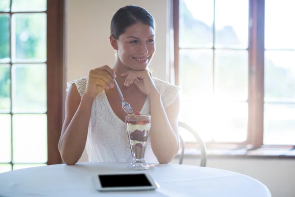 Femme souriante mangeant un dessert — Photo