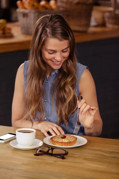 Chica sonriente comiendo pastelería — Foto de Stock