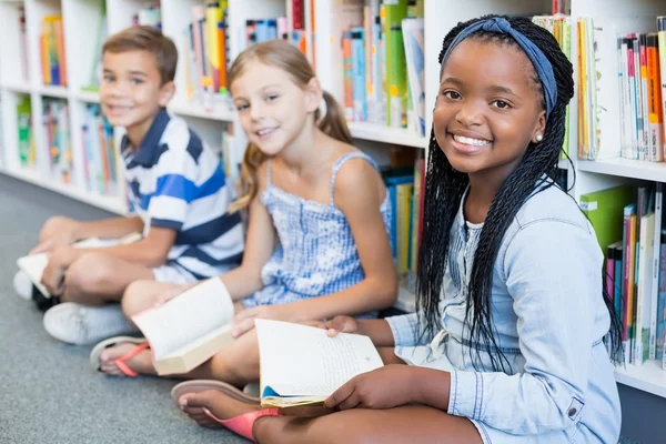 School kids reading book in library — Stock Photo, Image