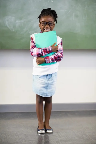 Schoolgirl holding file in classroom — Stock Photo, Image