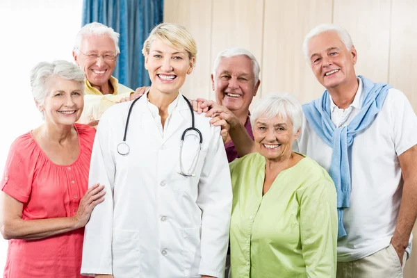Seniors putting their hands on nurse — Stock Photo, Image