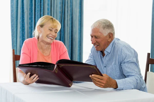 Senior couple looking at photo album — Stock Photo, Image