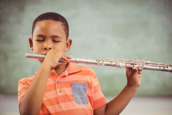 Colegial tocando flauta en el aula — Foto de Stock