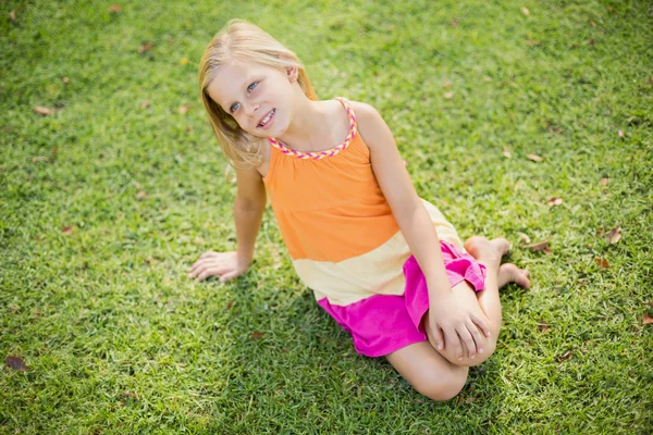 Jeune fille assise sur l'herbe — Photo