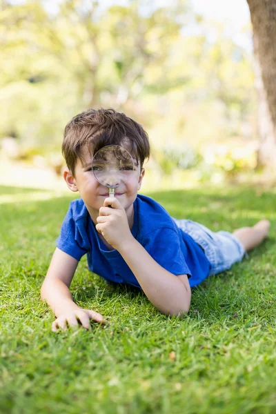 Çocuk elinde büyüteç tutuyor. — Stok fotoğraf