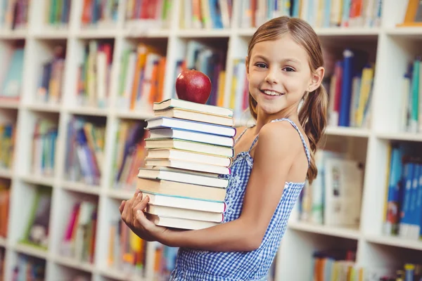 Chica de la escuela sosteniendo pila de libros — Foto de Stock