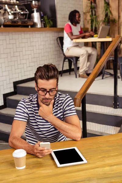 Man sitting at table using smartphone — Stock Photo, Image