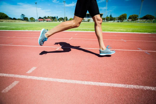 Female athlete running on the running track — Stock Photo, Image