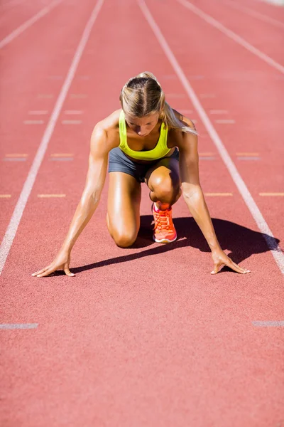 Atleta feminina pronta para correr em pista de corrida — Fotografia de Stock