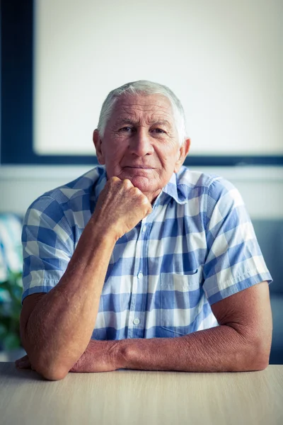 Portrait of senior man sitting in living room — Stock Photo, Image