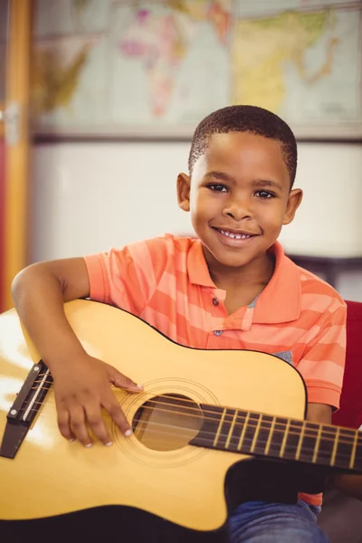 Skolpojke spela gitarr i klassrummet — Stockfoto