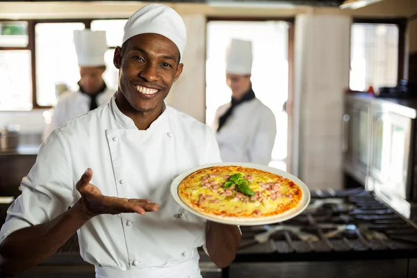 Chef sorrindo mostrando pizza — Fotografia de Stock