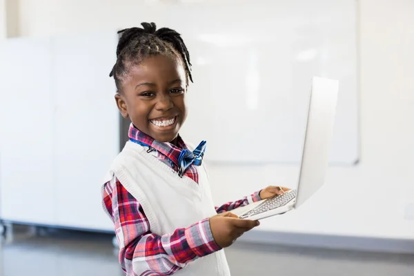 Skolflicka med laptop i klassrummet — Stockfoto