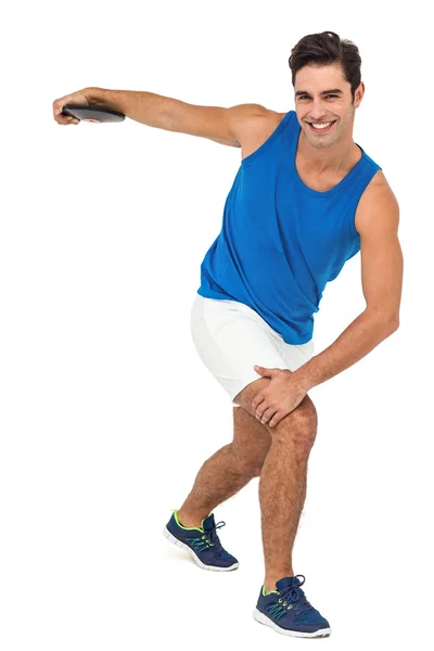 Мужчина спортсмен, играющий в метание диска на белом фоне — стоковое фото