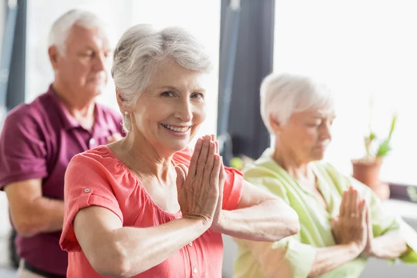 Seniorer gör yoga med slutna ögon — Stockfoto