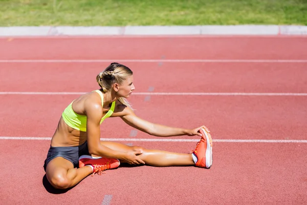 Atleta femminile che si scalda sulla pista da corsa — Foto Stock