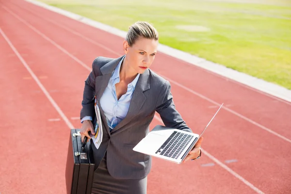 Donna d'affari pronta a correre con un portatile e una valigetta — Foto Stock
