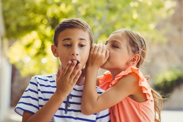 男の子の耳に秘密をささやく女の子 — ストック写真