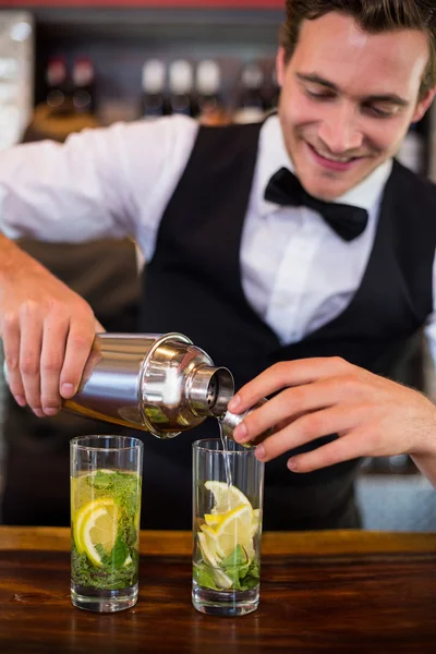 Bartendern hälla drink från shaker till glas — Stockfoto