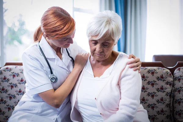 Doutor consolando mulher idosa — Fotografia de Stock