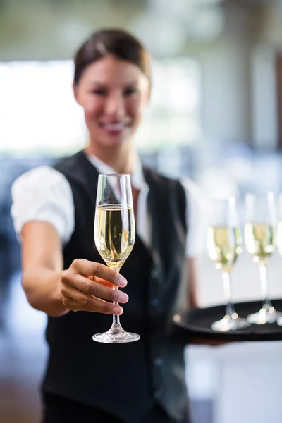 Lachende serveerster aanbieden van champagne — Stockfoto