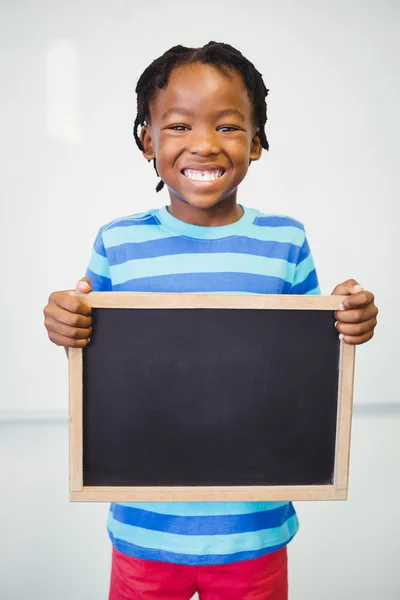 Scuola ragazzo holding ardesia in classe — Foto Stock