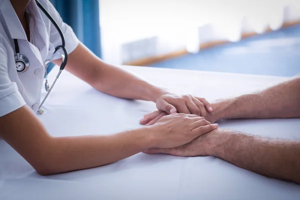 Seção média do médico feminino consolando o homem idoso na sala de estar — Fotografia de Stock