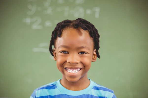 Skolpojke leende i klassrummet — Stockfoto