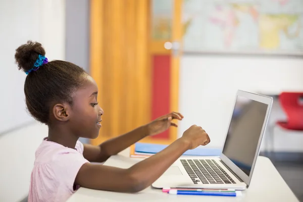Schoolmeisje met laptop in de klas — Stockfoto