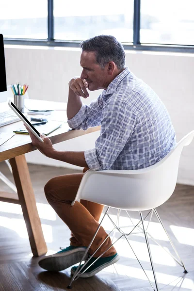 Empresário refletindo e usando tablet — Fotografia de Stock
