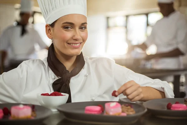 Female chef finishing dessert plates — Stock Photo, Image