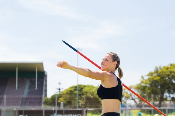 Boldog női sportoló, arról, hogy dobja a dárdát — Stock Fotó