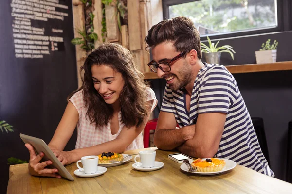 Casal usando comprimido na cafetaria — Fotografia de Stock