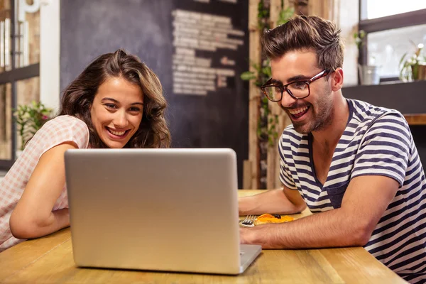 Couple using laptop in cafeteria — Stock Photo, Image