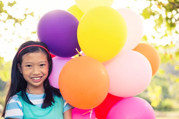 Mädchen hält Luftballons im Park — Stockfoto