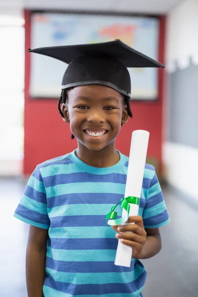 Schoolboy holding certificate in classroom — Stock Photo, Image