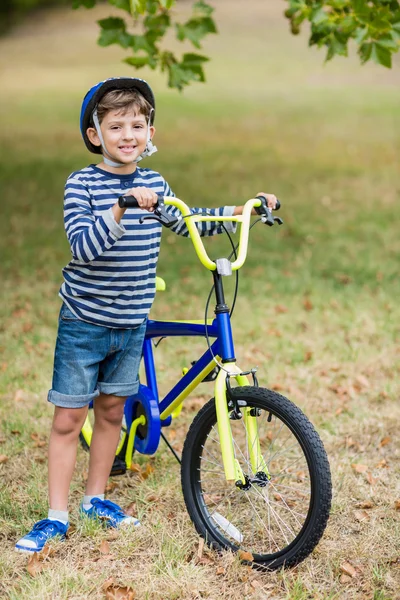 Ragazzo in piedi con bicicletta nel parco — Foto Stock