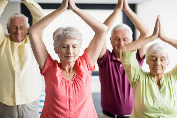 Mayores haciendo yoga con los ojos cerrados — Foto de Stock